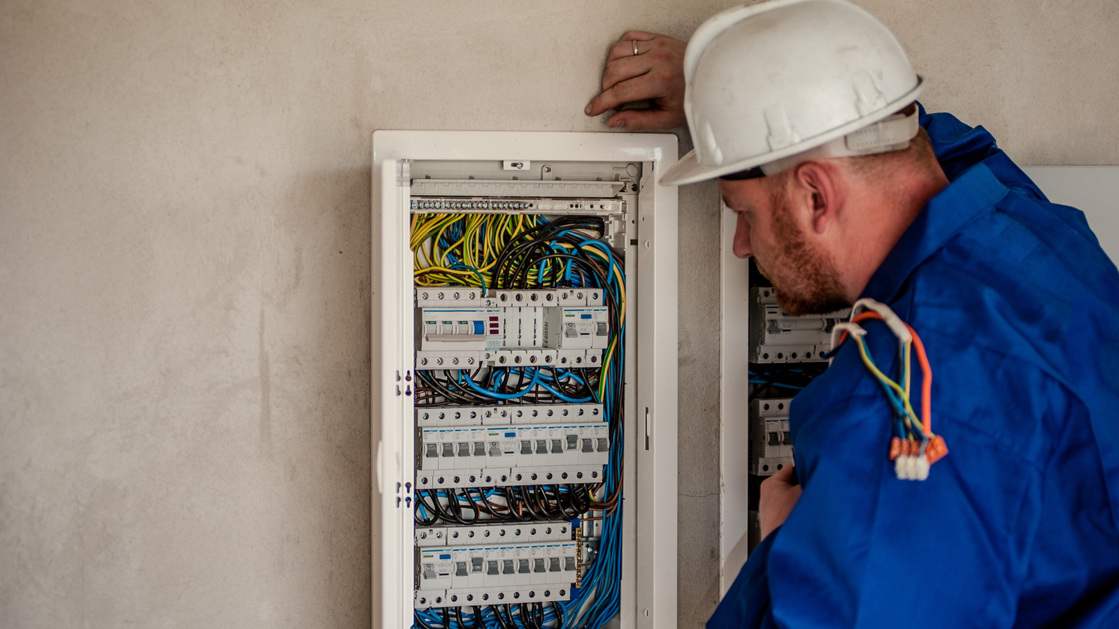 Eletricista realizando manutenção em quadro de energia